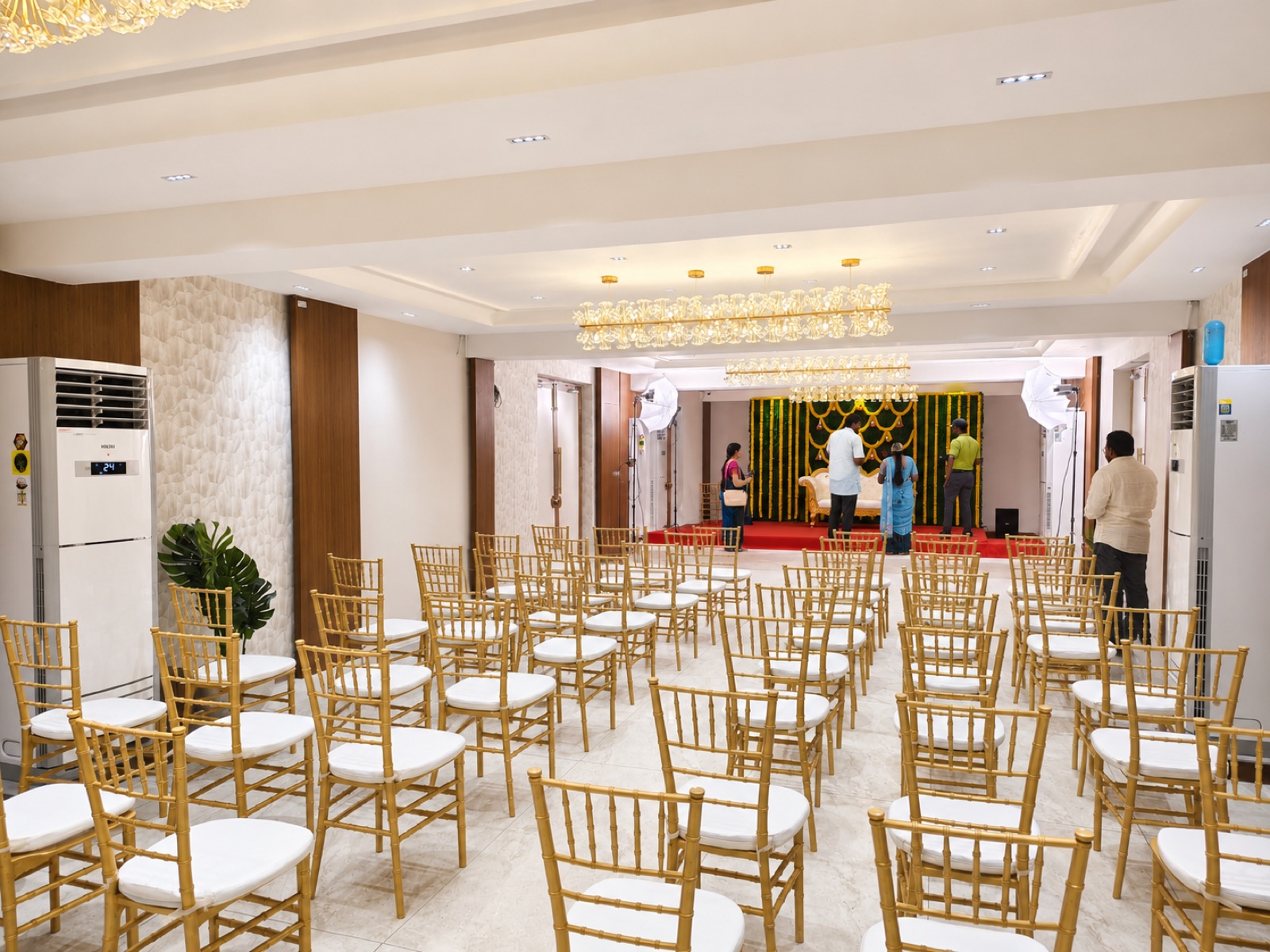 Taara party hall — gold chiavari chairs with floral stage